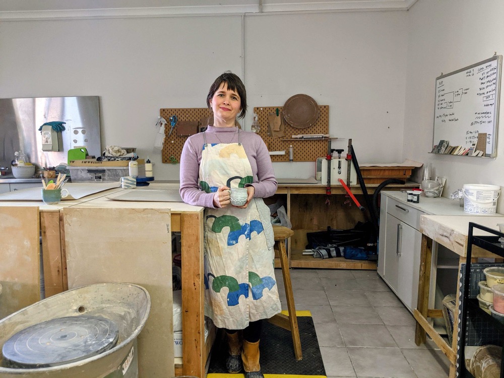 Anne Sherman holding ceramics in Home Clay Studio