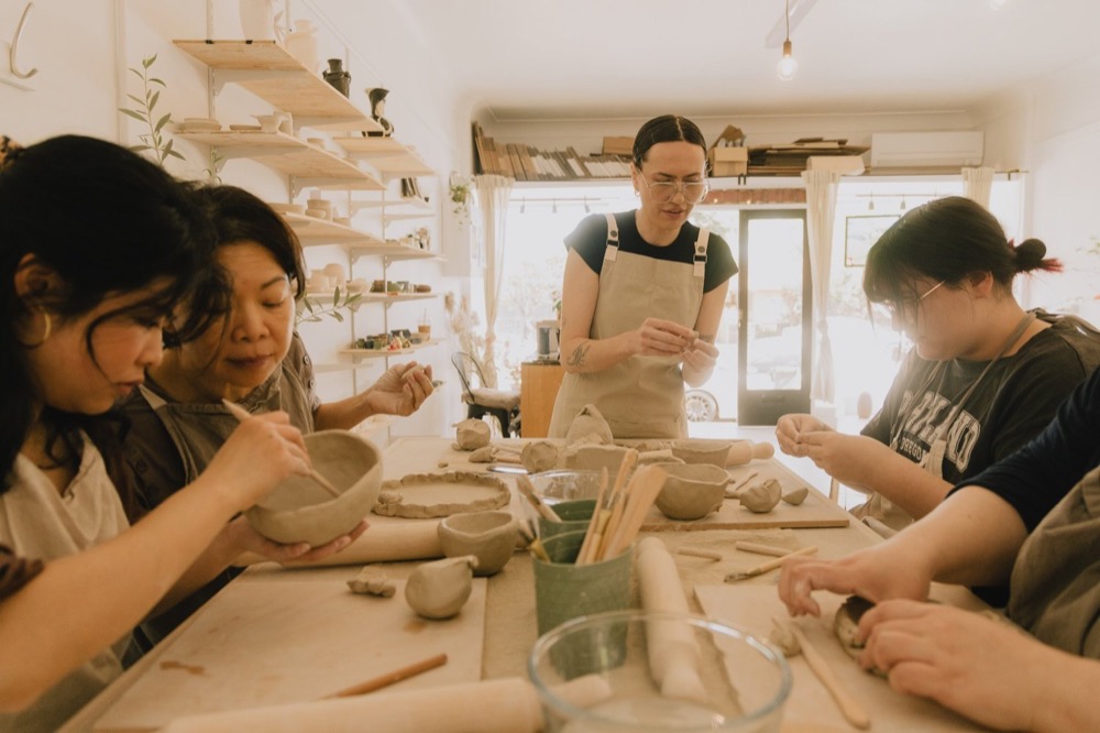 People making pottery around a table at Sunroom Studio